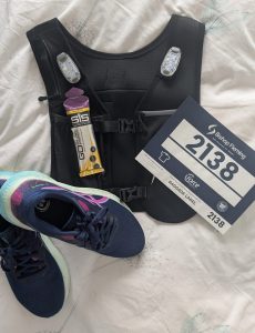 Race t shirt, race number, running vest, running shoes, running shorts laid out ready for running the great west run